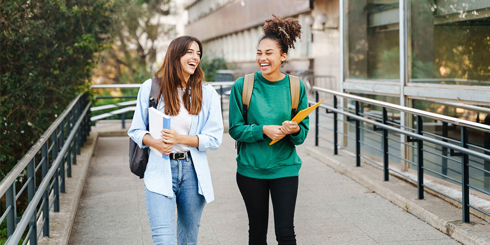 Two students walking through university campus grounds