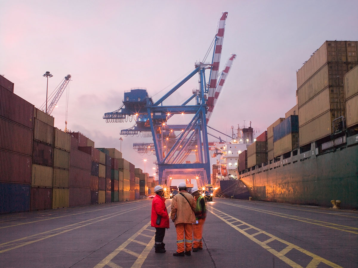 Port workers standing in cargo storage area